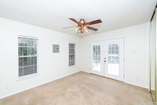 carpeted spare room featuring electric panel, ceiling fan, a textured ceiling, and french doors