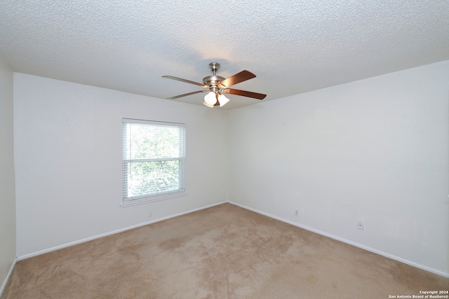 unfurnished room featuring a textured ceiling, light carpet, and ceiling fan