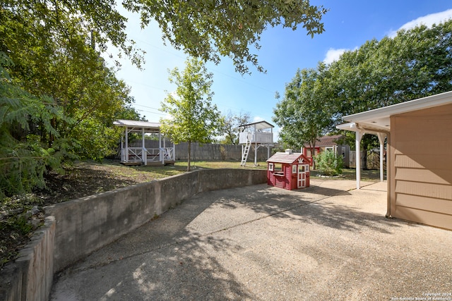 view of patio with a shed and a playground