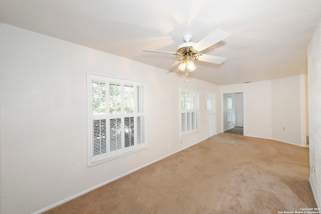 carpeted spare room with ceiling fan