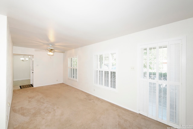 carpeted spare room with a wealth of natural light and ceiling fan