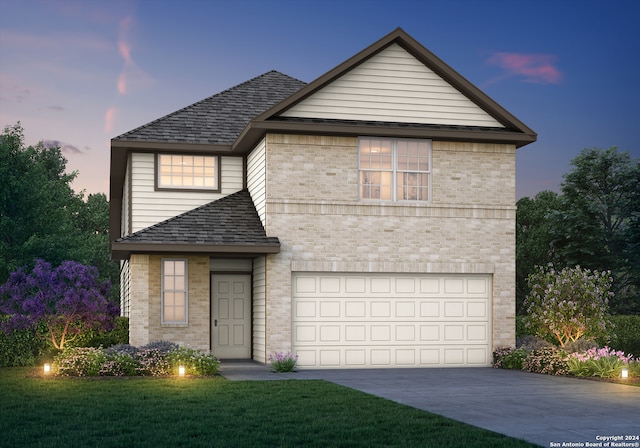 view of front of property with a yard and a garage