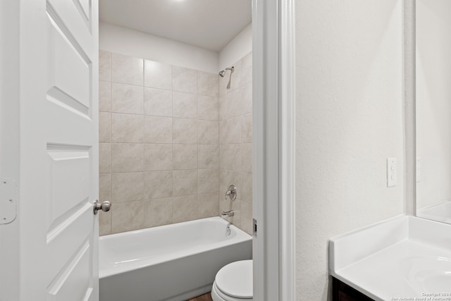 full bathroom with vanity, tiled shower / bath combo, and toilet