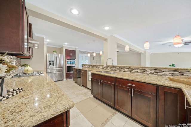 kitchen with appliances with stainless steel finishes, hanging light fixtures, sink, and backsplash