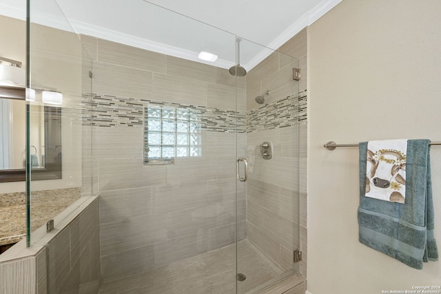 bathroom with crown molding and a shower with door