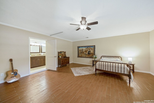 bedroom featuring ensuite bathroom, wood-type flooring, ceiling fan, and crown molding