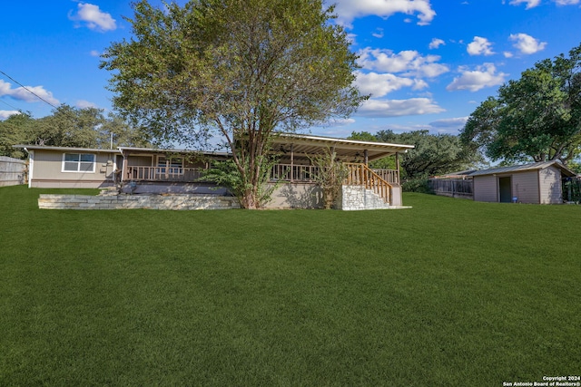 back of house with a lawn and a storage unit