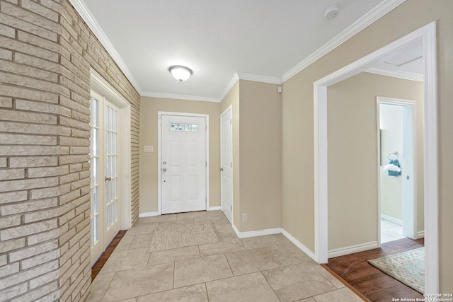 entrance foyer with ornamental molding, light hardwood / wood-style flooring, and a textured ceiling