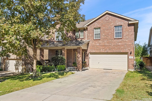 view of property featuring a garage and a front yard