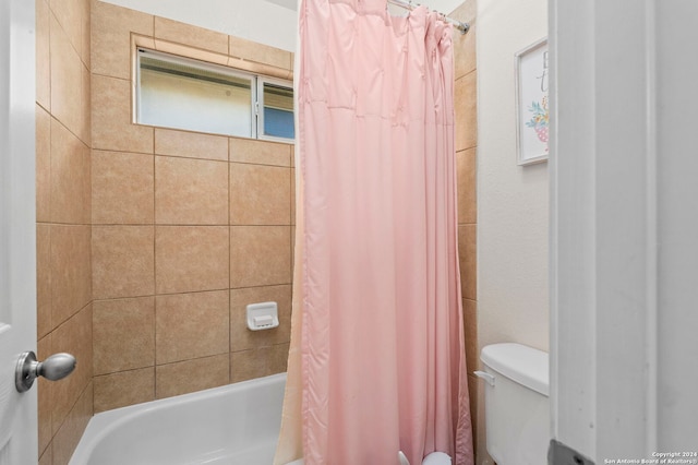 bathroom featuring toilet and shower / bath combination with curtain