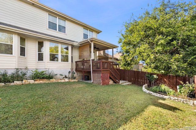 back of house featuring ceiling fan, a lawn, and a deck