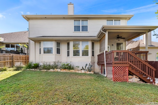 rear view of house featuring ceiling fan, a wooden deck, and a yard