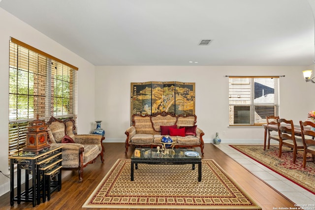 living room featuring a chandelier, wood-type flooring, and a healthy amount of sunlight