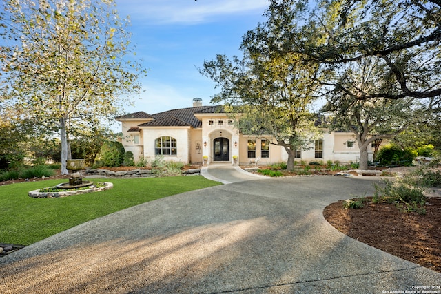 mediterranean / spanish-style home featuring a front yard