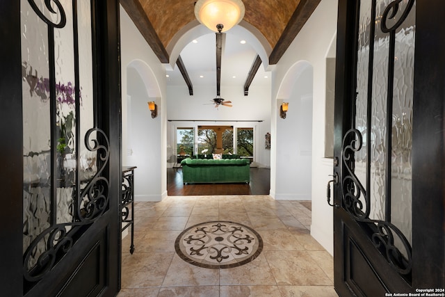 foyer with lofted ceiling with beams and ceiling fan