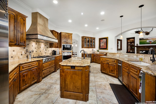 kitchen featuring hanging light fixtures, sink, an island with sink, ceiling fan, and appliances with stainless steel finishes