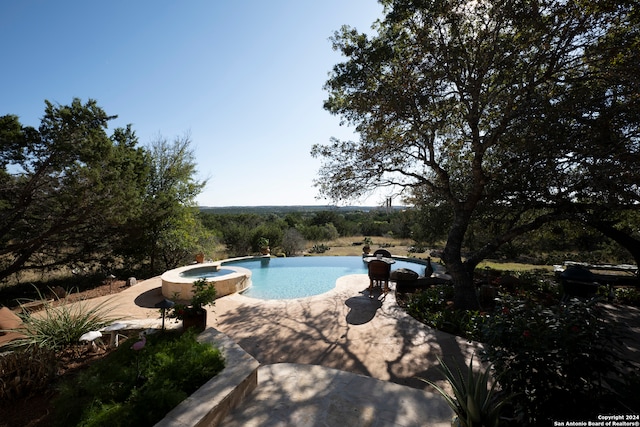 view of pool featuring an in ground hot tub and a patio area