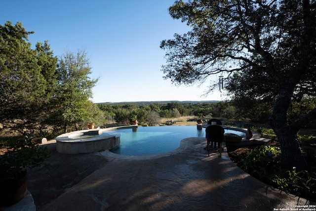 view of pool with a patio and an in ground hot tub