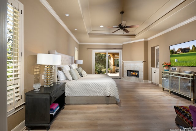 bedroom featuring crown molding, a raised ceiling, ceiling fan, and light hardwood / wood-style flooring