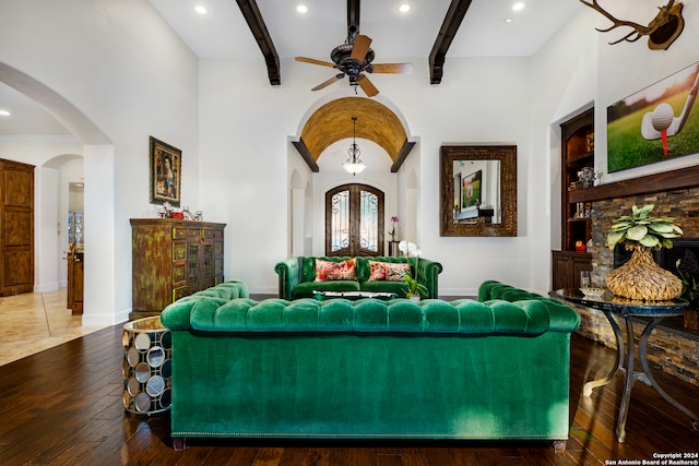 living room with beamed ceiling, ceiling fan, wood-type flooring, and high vaulted ceiling