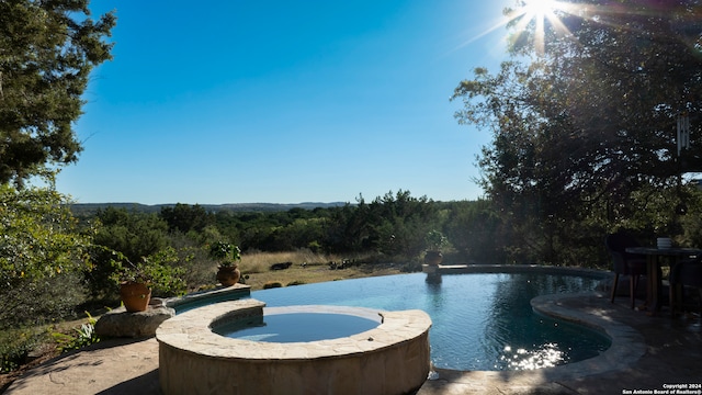 view of swimming pool featuring an in ground hot tub