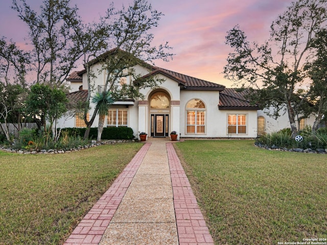 mediterranean / spanish house featuring a yard