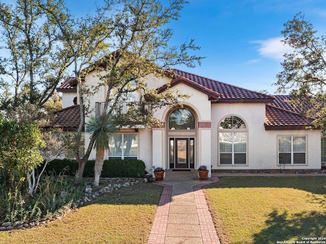 mediterranean / spanish home with a front yard