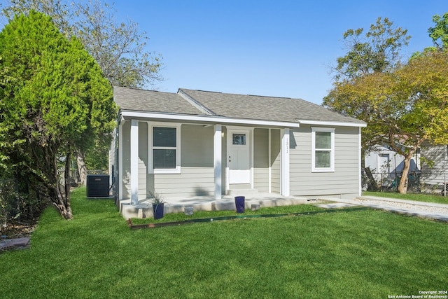 bungalow-style home with central AC unit, a front lawn, and covered porch