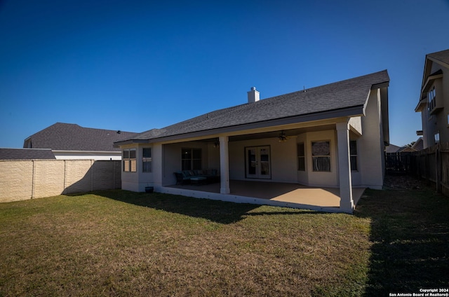 rear view of house featuring a lawn, ceiling fan, and a patio area