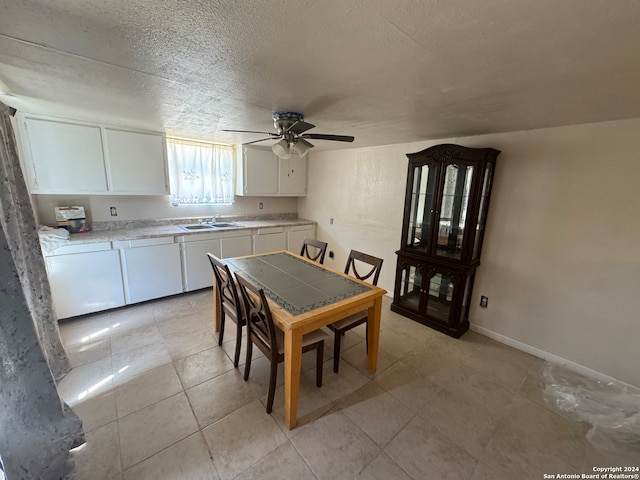 dining area with light tile patterned floors, ceiling fan, a textured ceiling, and sink