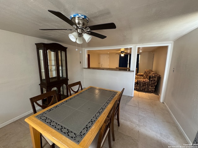 dining room with ceiling fan, a textured ceiling, and light tile patterned floors