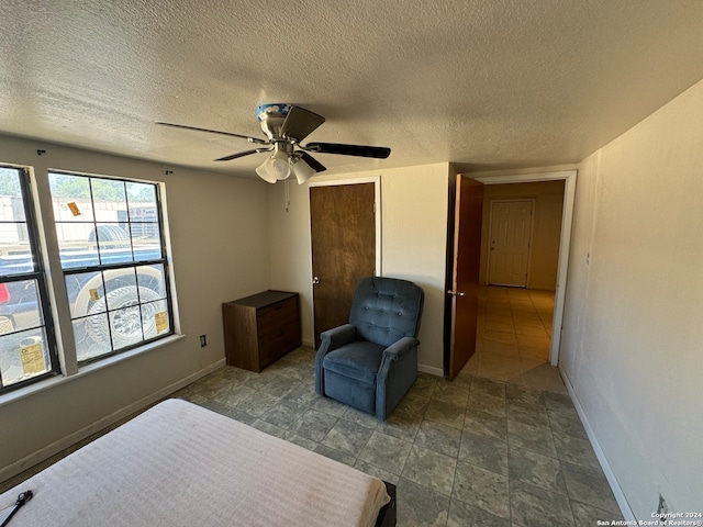 bedroom with a textured ceiling and ceiling fan