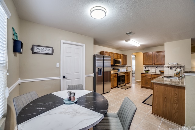 dining area with a textured ceiling and sink