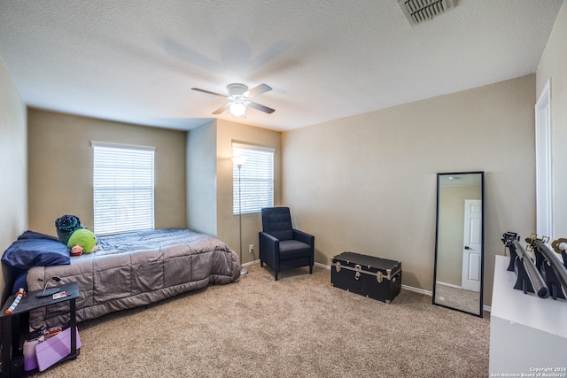 carpeted bedroom with a textured ceiling and ceiling fan