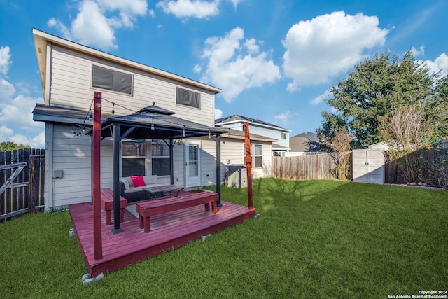 rear view of property featuring a deck, a yard, a gazebo, and an outdoor hangout area