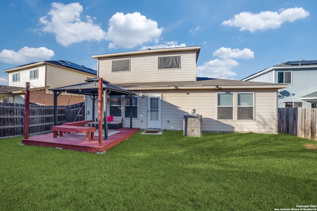 rear view of house with a wooden deck, a lawn, and a gazebo