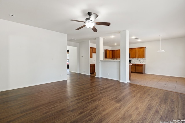 unfurnished living room featuring wood-type flooring and ceiling fan