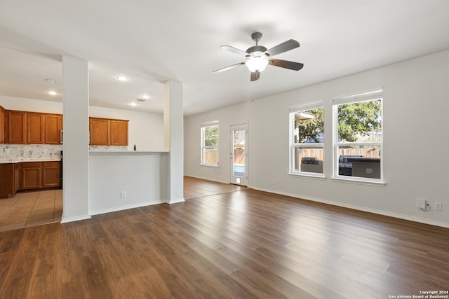 unfurnished living room with ceiling fan and wood-type flooring