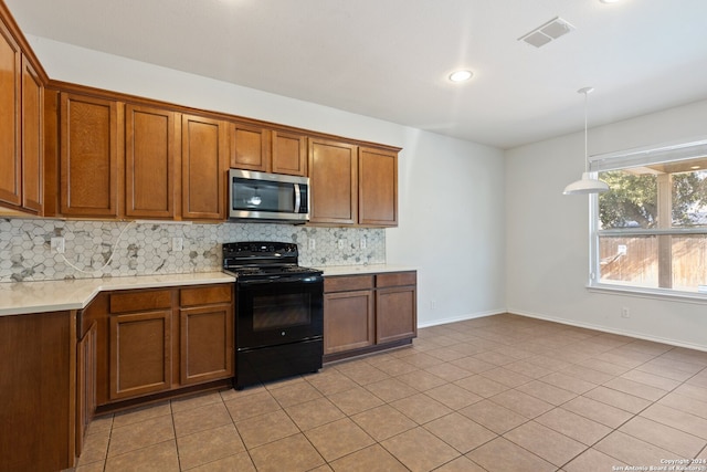 kitchen with black / electric stove, decorative backsplash, light tile patterned floors, and pendant lighting