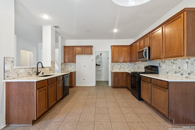 kitchen featuring black appliances, decorative backsplash, light tile patterned flooring, and sink