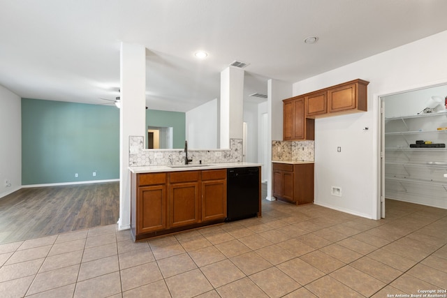 kitchen featuring ceiling fan, sink, black dishwasher, light hardwood / wood-style floors, and decorative backsplash