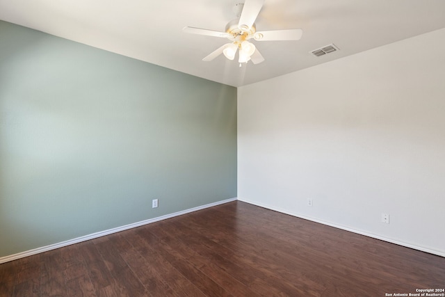 empty room with ceiling fan and dark hardwood / wood-style flooring