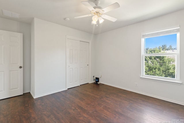 unfurnished bedroom featuring a closet, ceiling fan, and dark hardwood / wood-style flooring