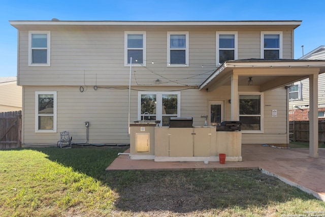 back of house featuring a patio area and a lawn