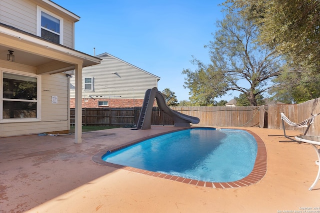 view of pool with a water slide and a patio