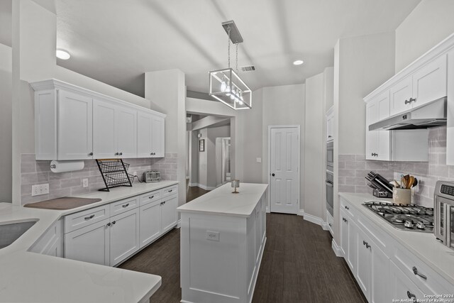 kitchen with backsplash, white cabinetry, a kitchen island with sink, and appliances with stainless steel finishes