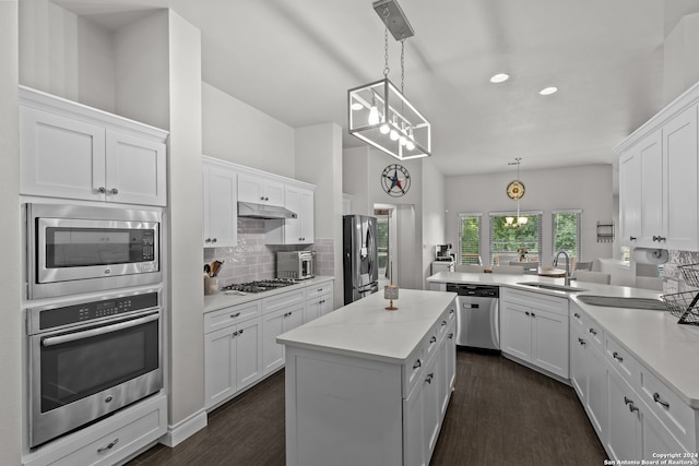 kitchen featuring white cabinetry, kitchen peninsula, appliances with stainless steel finishes, and decorative light fixtures