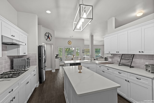 kitchen with stainless steel appliances, hanging light fixtures, sink, and a kitchen island