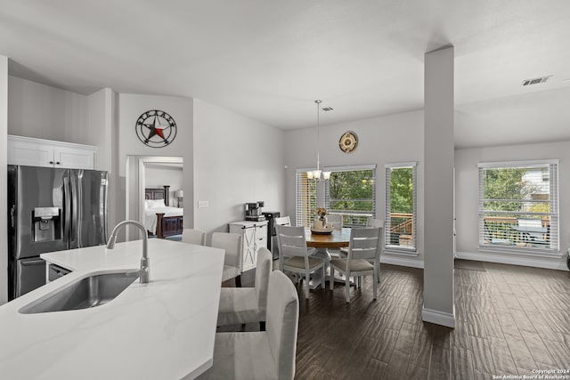 kitchen featuring dark hardwood / wood-style flooring, light stone counters, white cabinets, stainless steel refrigerator with ice dispenser, and decorative light fixtures