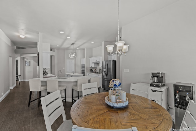 dining space with dark hardwood / wood-style flooring, a chandelier, and sink